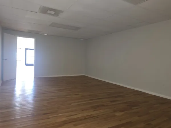 a view of wooden floor and windows in a room