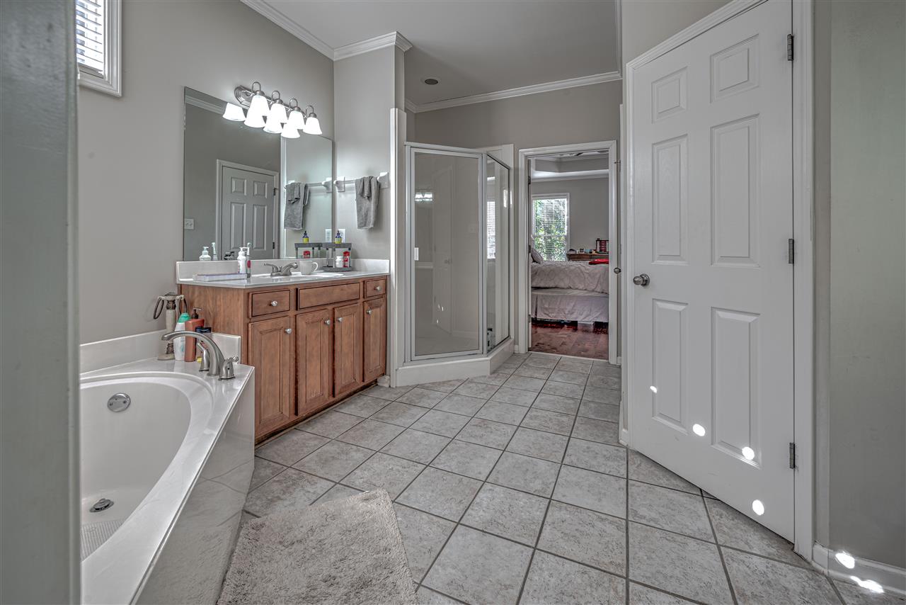 10388 Pilot Rock Road Collierville, TN 38017 - Photo 7 of 24 Featuring 10 ft. ceiling with crown molding, tile floor, corner whirlpool, separate shower, 4' his and 5' hers vanities and 12' walk-in closet (view from closet).