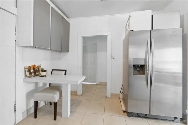 a kitchen with a refrigerator and table chair