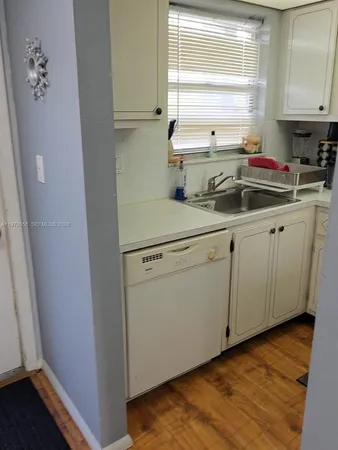 a kitchen with a sink cabinets and a window