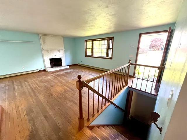 a view of an entryway with wooden floor and a fireplace
