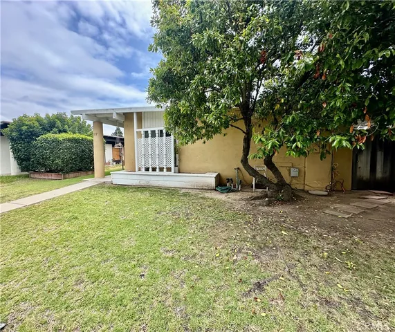 a view of a house with backyard and tree