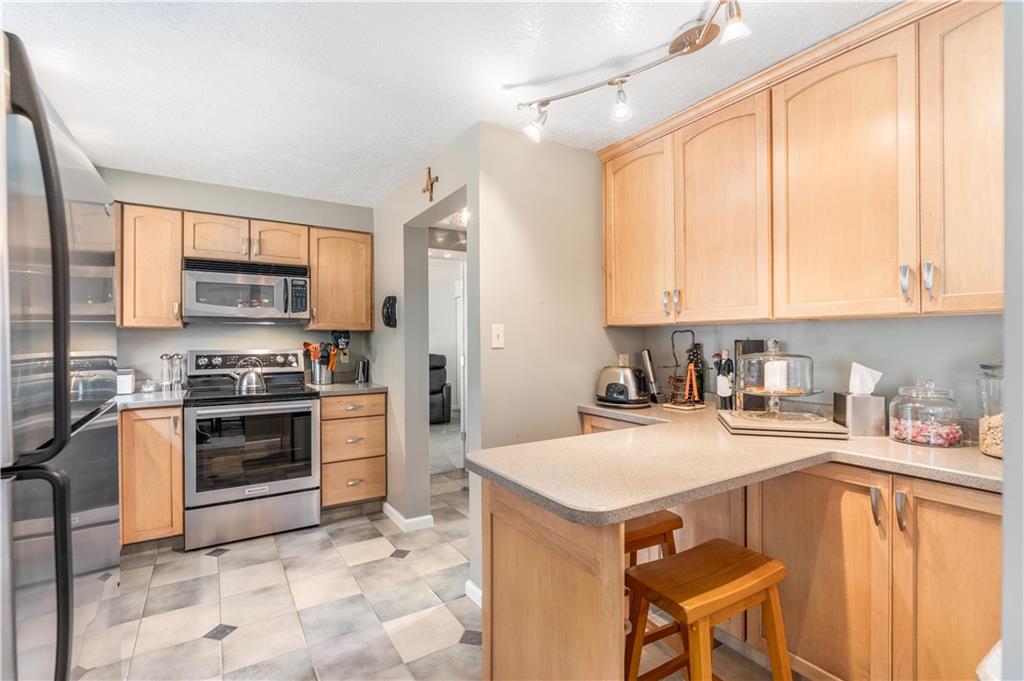 79 Fawnvue Drive McKees Rocks, PA 15136 - Photo 13 of 33 a kitchen with a stove a sink a microwave and cabinets
