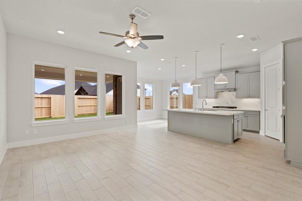 a large kitchen with stainless steel appliances kitchen island a large counter top and a chandelier
