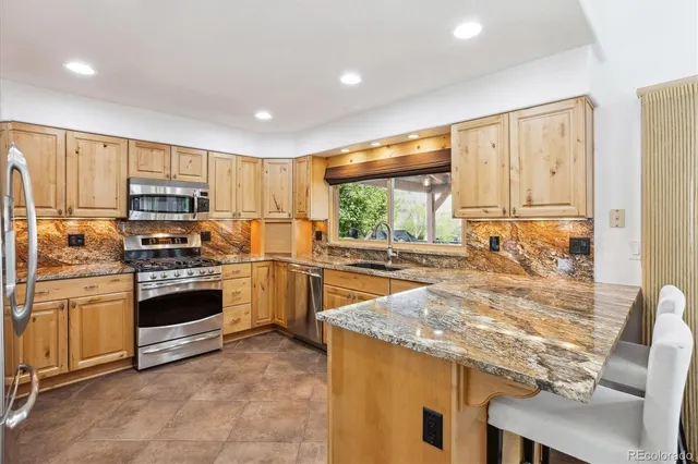 a kitchen with stainless steel appliances granite countertop a stove refrigerator and a microwave