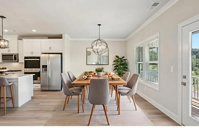 5960 Molo Lane Cumming, GA 30041 - Photo 7 of 17 a dining room with furniture a chandelier and wooden floor