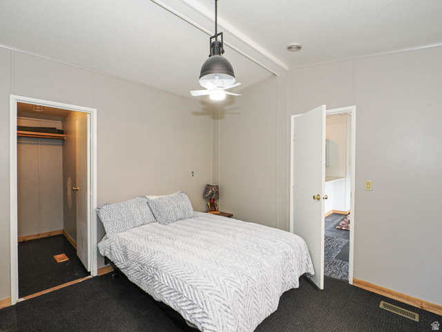94 Spring Canyon Road Coalville, UT 84017 - Photo 42 of 50 Carpeted room featuring a ceiling-mounted light fixture with fan, light gray wall paneling, and an adjacent closet with wood-finish flooring