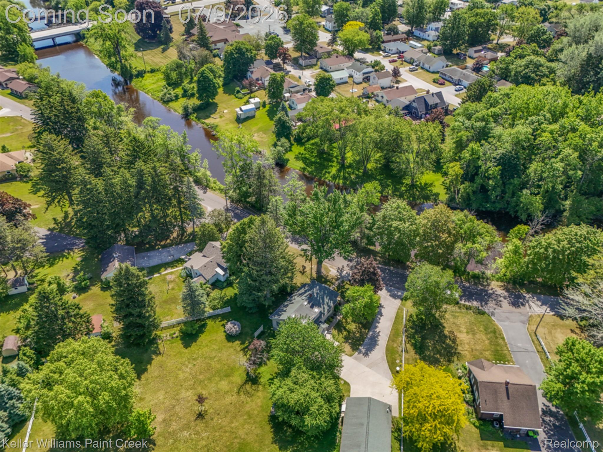 204 Russell Road Kawkawlin, MI 48631 - Photo 66 of 82 Aerial perspective showcasing expansive green spaces, mature trees, and a visible waterway with surrounding foliage