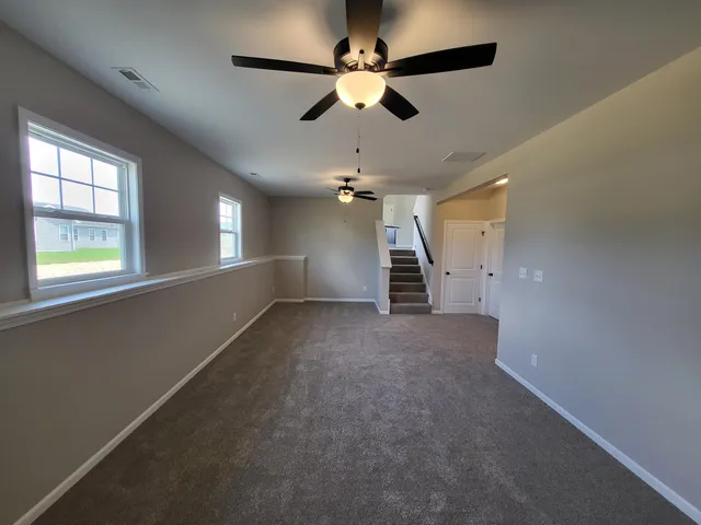 an empty room with stairs and windows