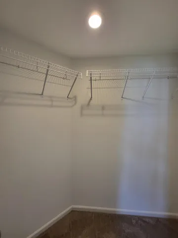 an empty room with ceiling fan and windows