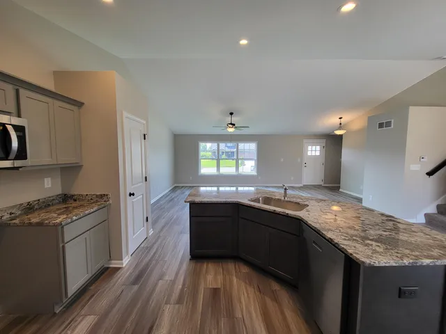 a kitchen with granite countertop stainless steel appliances and wooden cabinets