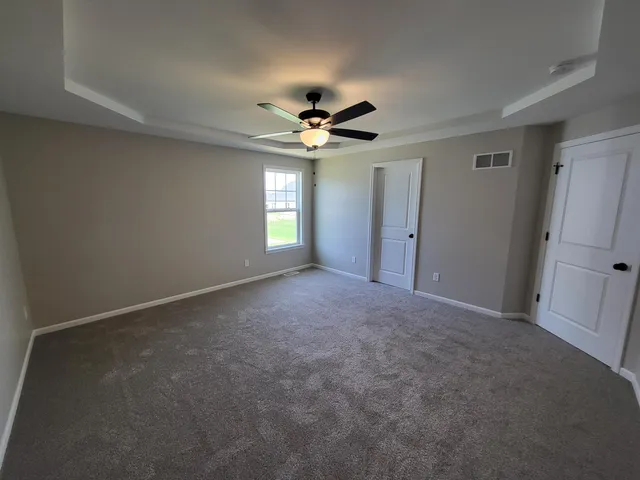 a view of a hallway with a chandelier fan and windows