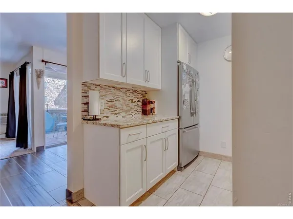 a kitchen view of a refrigerator sink and cabinets