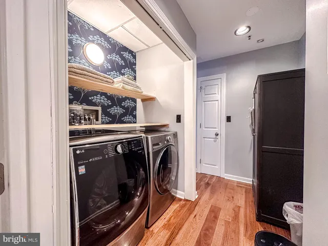 a view of a livingroom with wooden floor and kitchen space