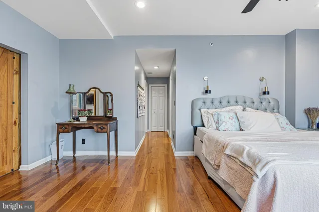 a bedroom with a bed and wooden floor