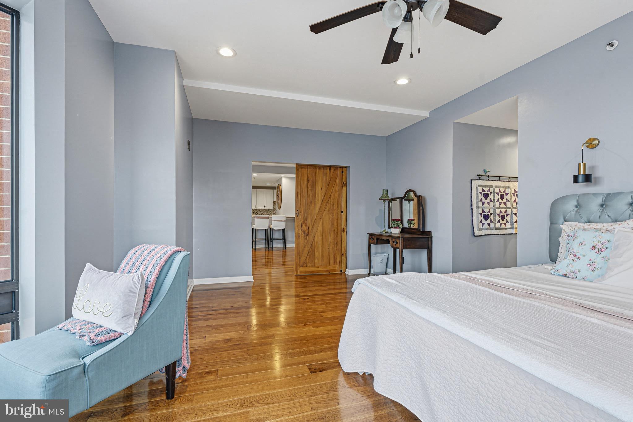 10 East Lee Street, Unit 808 Baltimore, MD 21202 - Photo 18 of 32 a bedroom with a bed and wooden floor