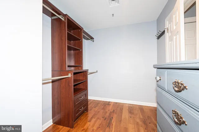 a view of walk in closet with empty racks