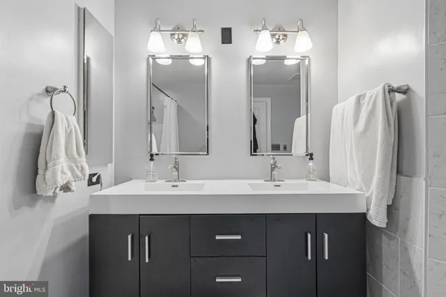 a bathroom with a double vanity sink a mirror and a bathtub