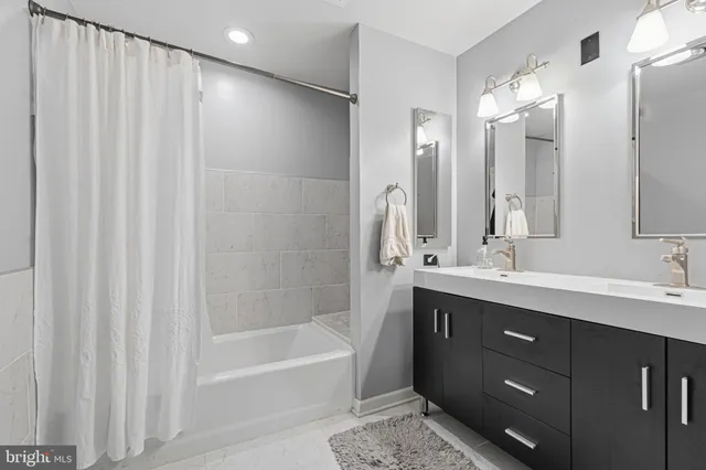 a bathroom with a sink a toilet a mirror and shower