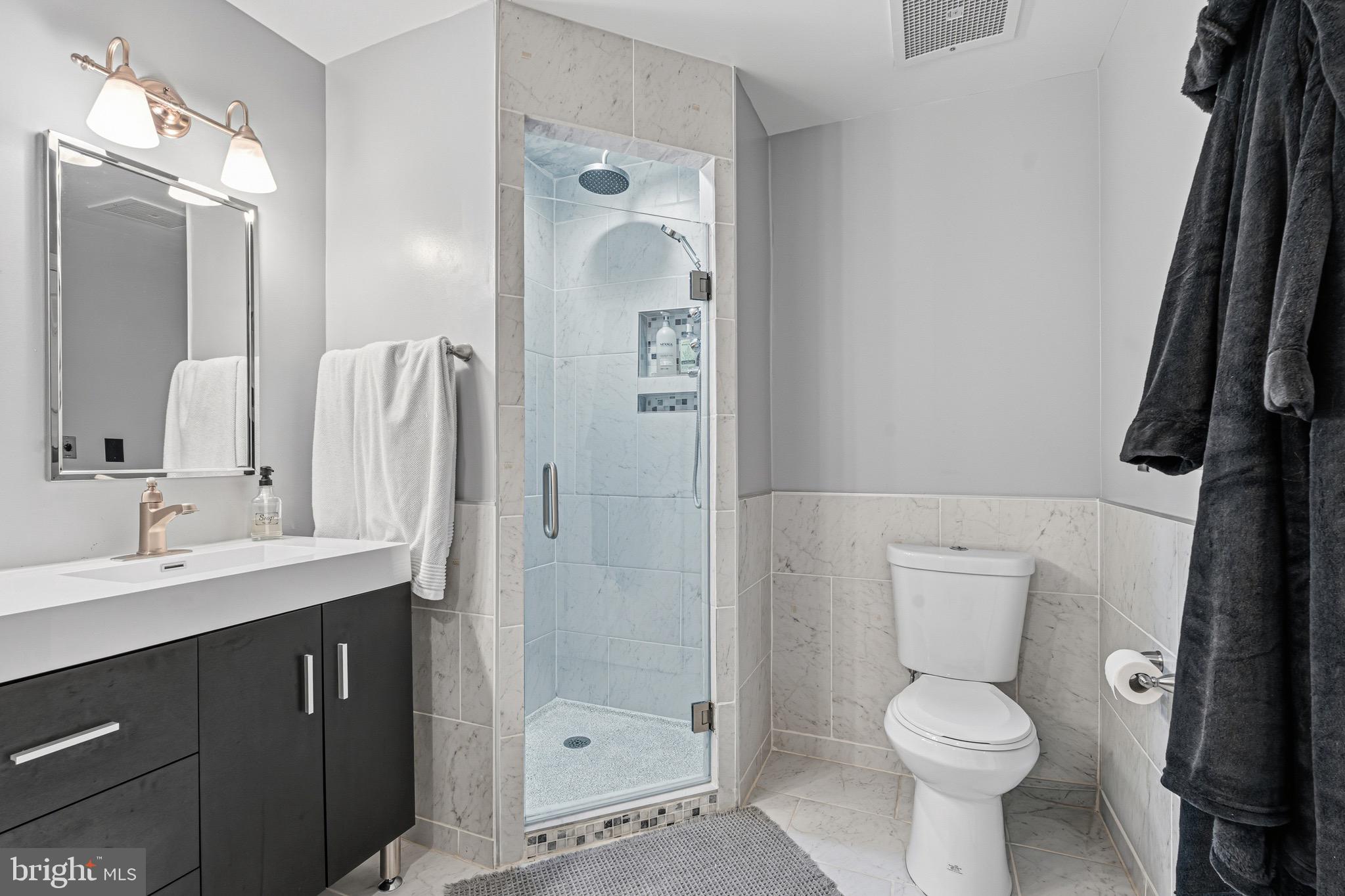 10 East Lee Street, Unit 808 Baltimore, MD 21202 - Photo 24 of 32 a bathroom with a sink a toilet a mirror and shower