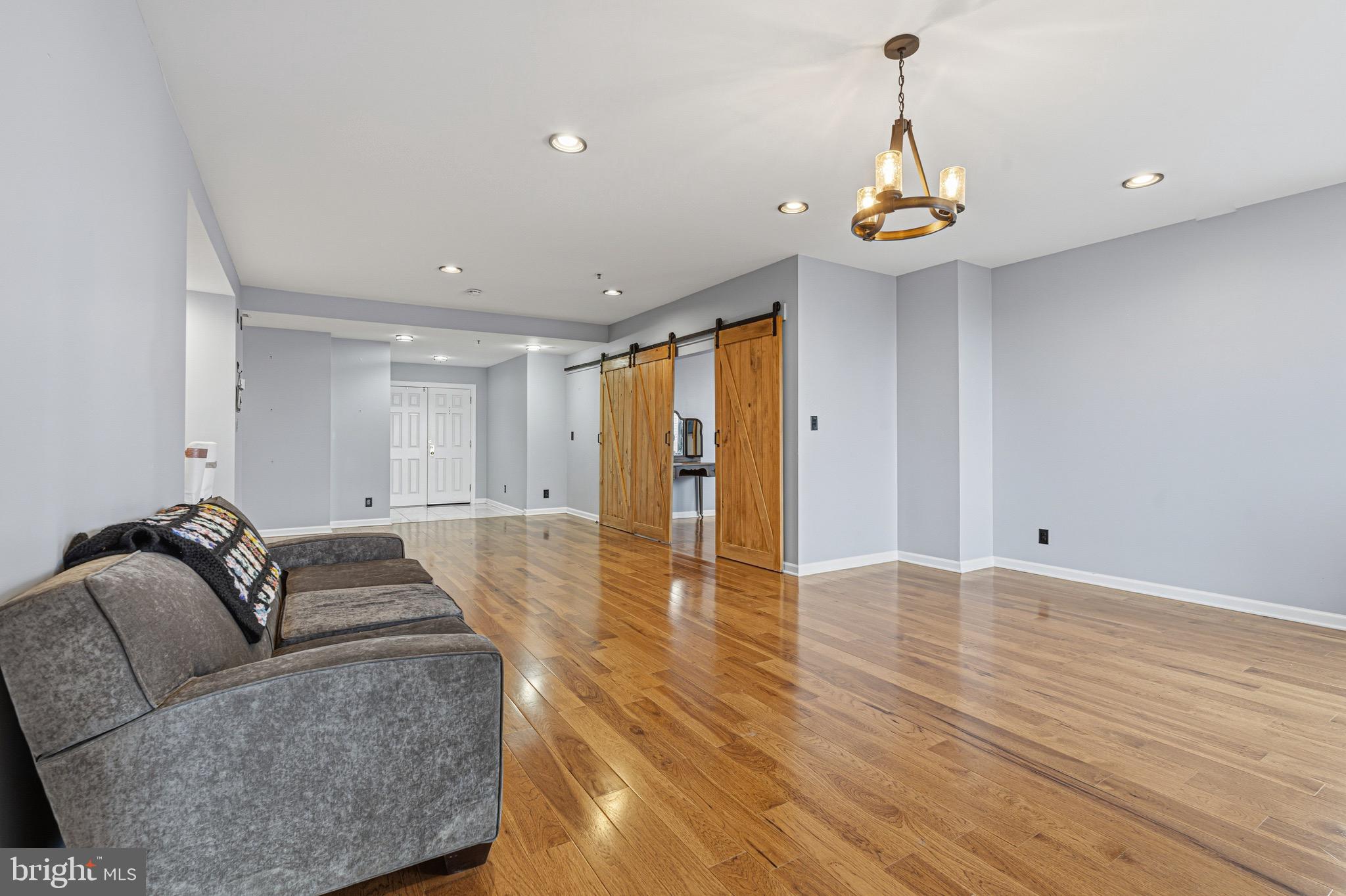 10 East Lee Street, Unit 808 Baltimore, MD 21202 - Photo 4 of 32 a living room with furniture and wooden floor