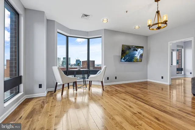 a living room with a clock on wall and a table