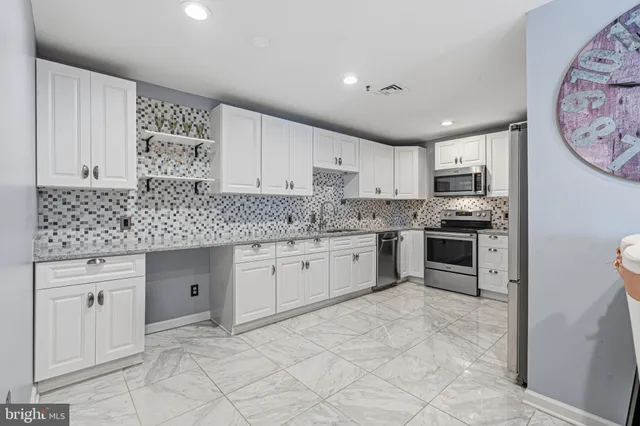 a kitchen with stainless steel appliances granite countertop a stove top oven microwave and cabinets