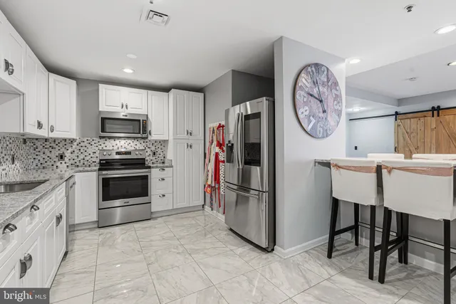 a kitchen with granite countertop cabinets and chair