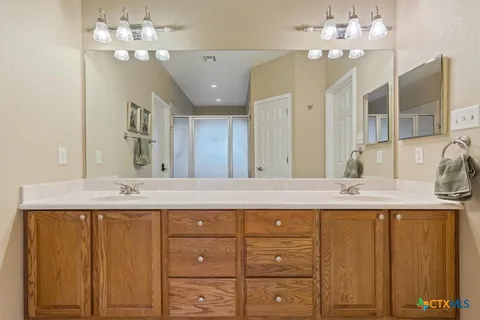 a bathroom with a sink vanity granite and a mirror