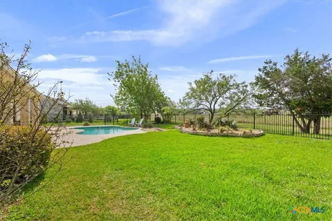 a view of yard with swimming pool and green space