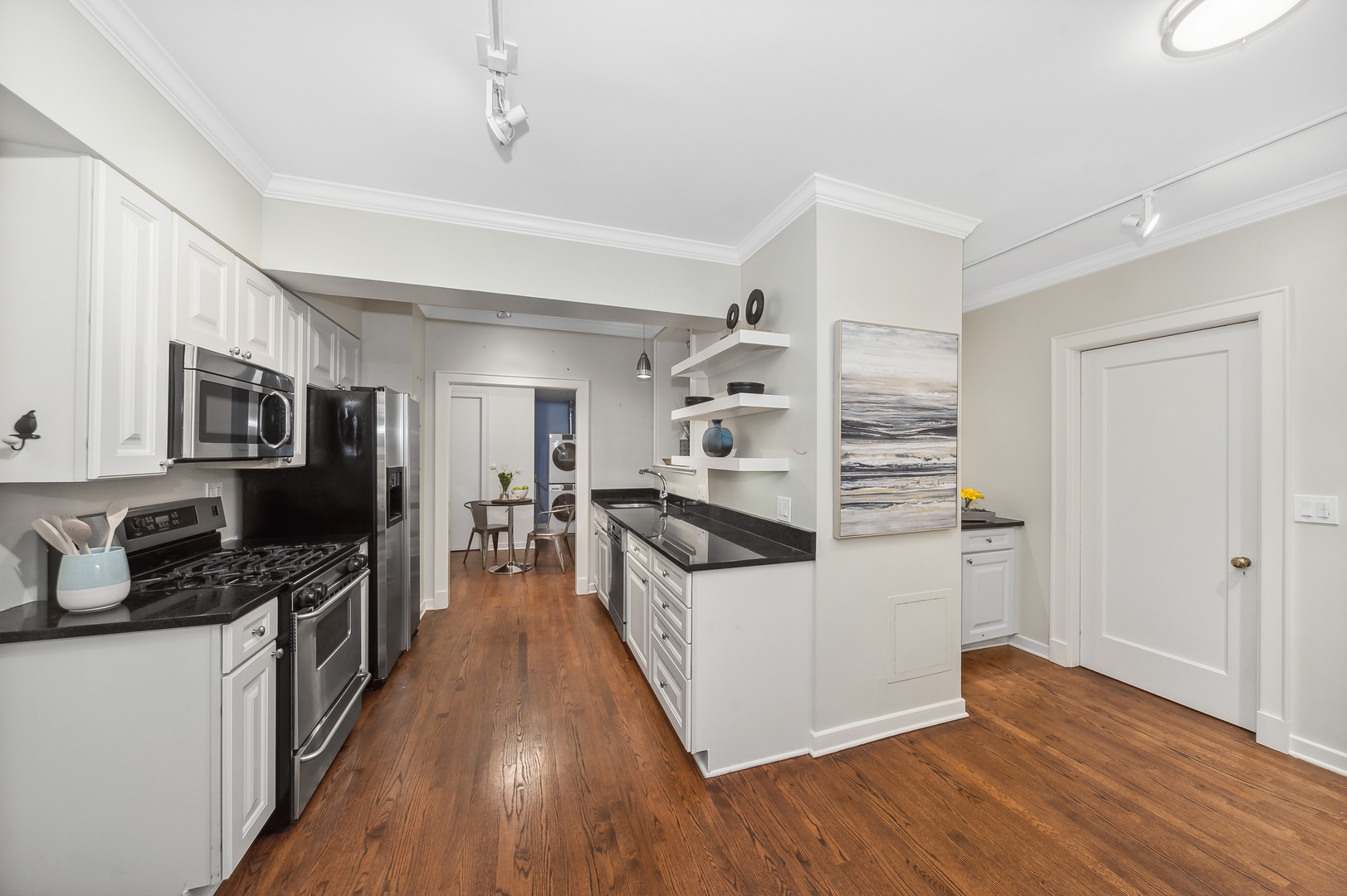3100 North Sheridan Road, Unit 4B Chicago, IL 60657 - Photo 8 of 19 a kitchen with stainless steel appliances a stove top oven a sink a refrigerator white cabinets and wooden floor