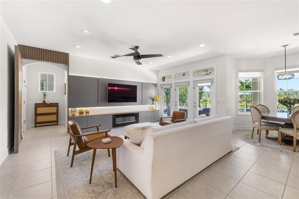 8764 Lookout Pointe Drive Windermere, FL 34786 - Photo 24 of 53 a living room with furniture a flat screen tv and a large window
