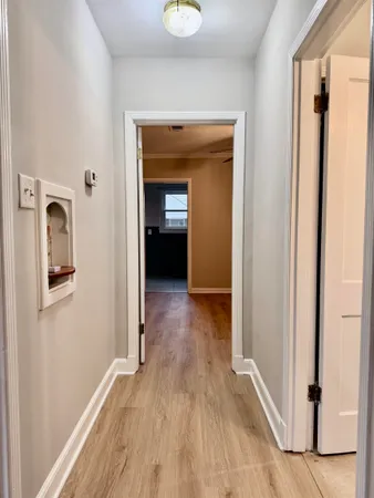 a view of a hallway with wooden floor and closet