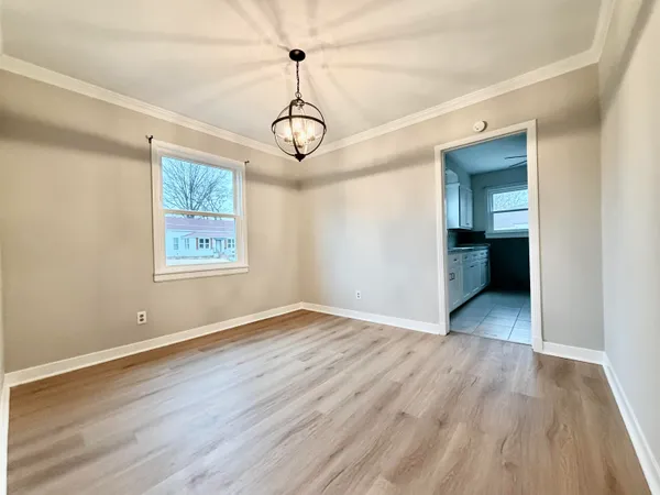 a view of empty room with wooden floor and ceiling fan