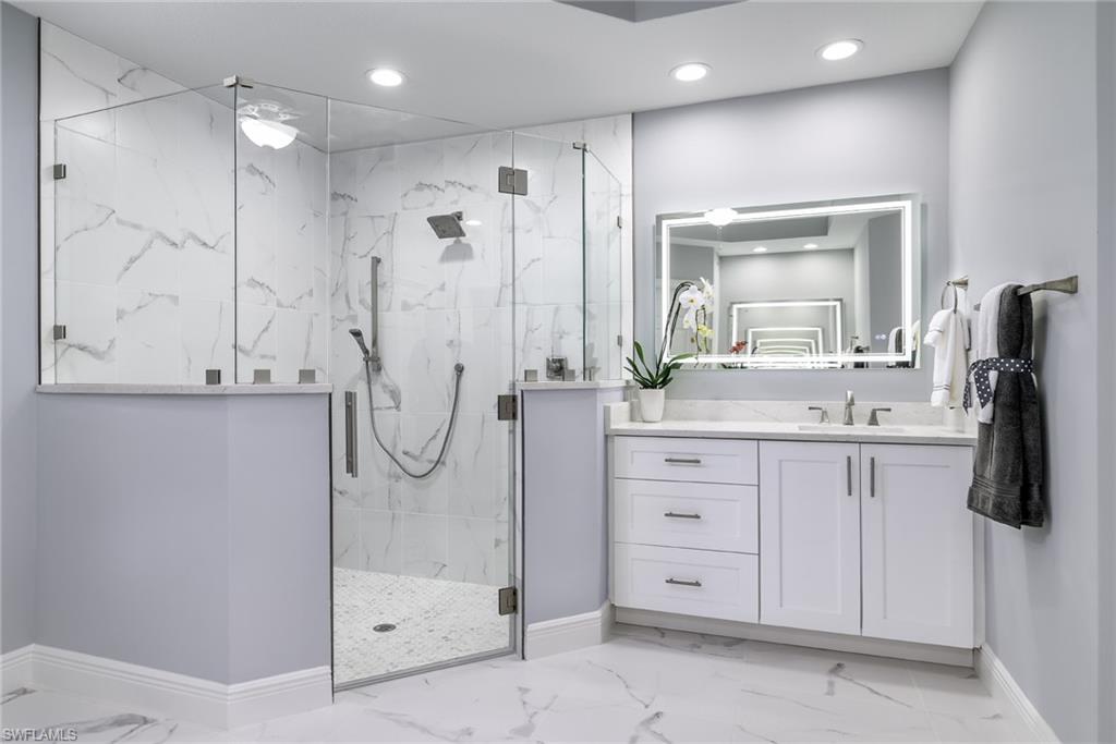 2090 Aberdeen Lane, Unit 101 Naples, FL 34109 - Photo 9 of 37 a bathroom with a double vanity sink mirror and shower