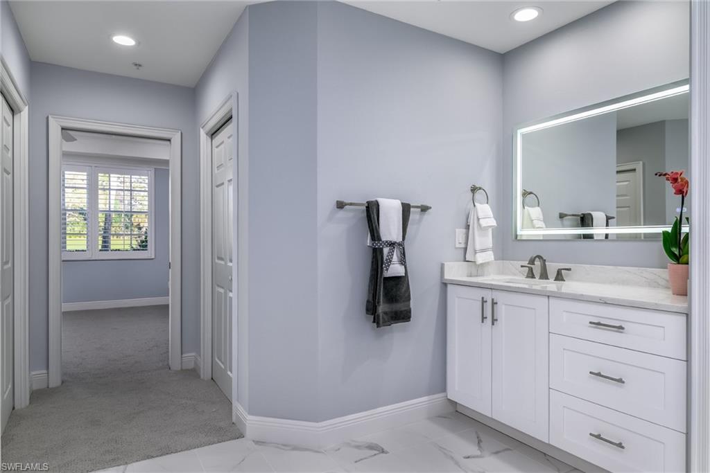 2090 Aberdeen Lane, Unit 101 Naples, FL 34109 - Photo 10 of 37 a bathroom with a sink a mirror and cabinets