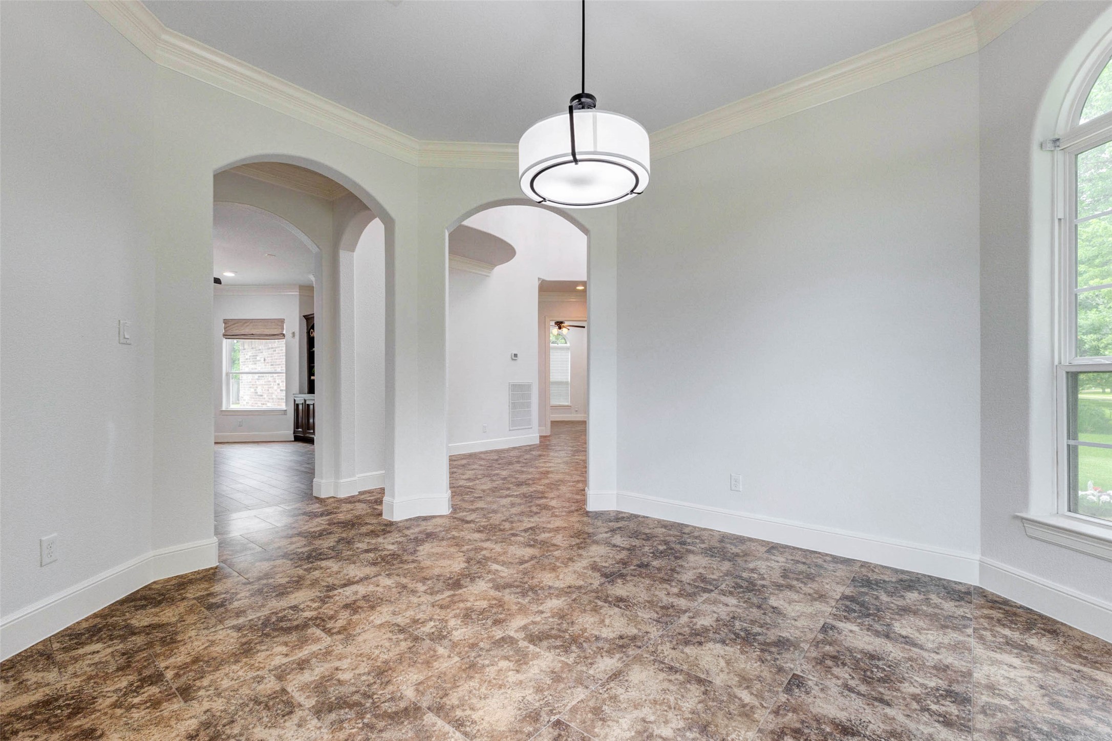 5327 Whitmore Fulshear, TX 77441 - Photo 20 of 50 Another view showcases the impressive scale of the dining room, where abundant natural light and elegant architectural details create a warm, welcoming atmosphere for entertaining.