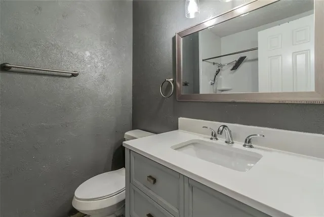 a bathroom with a sink toilet and mirror