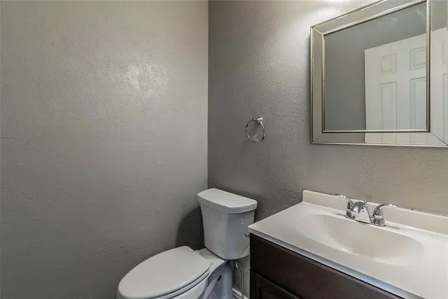 a bathroom with a sink mirror and toilet