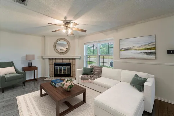 a living room with furniture a fireplace and a large window
