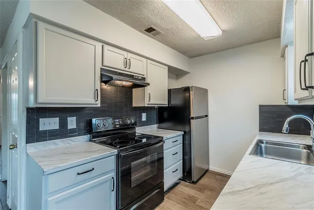 a kitchen with stainless steel appliances granite countertop a stove and a refrigerator