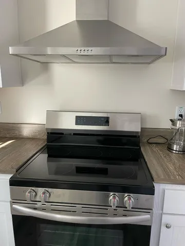 a view of a room with wooden floor and a bathroom