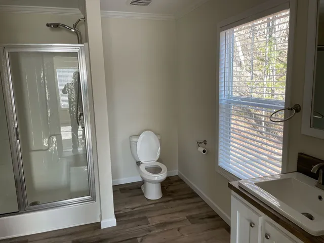a view of hallway with window and wooden floor