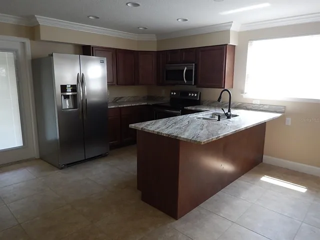 a kitchen with stainless steel appliances granite countertop a refrigerator a sink and dishwasher