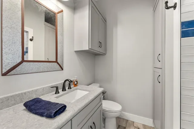 a bathroom with a granite countertop sink and a mirror