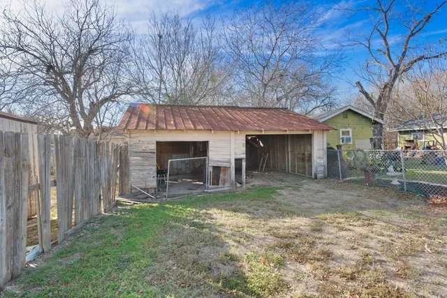 a view of a house with a yard and large tree
