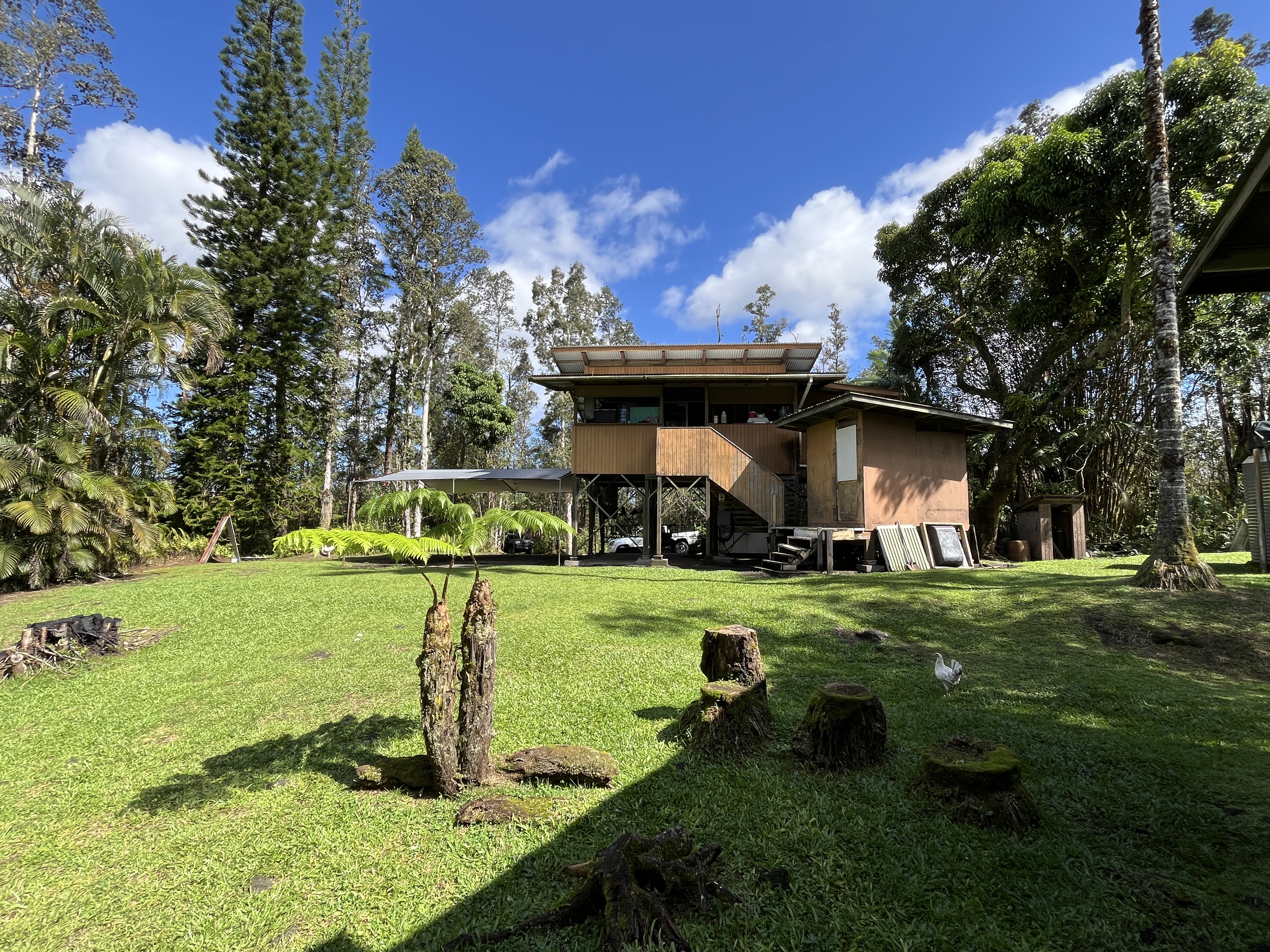 16-1088 Opeapea Road Kurtistown, HI 96760 - Photo 1 of 29 a front view of a house with a yard porch and wooden fence