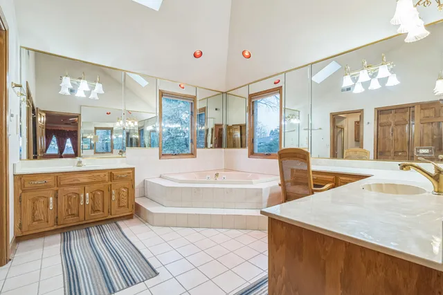 a spacious bathroom with a sink double vanity granite and a mirror
