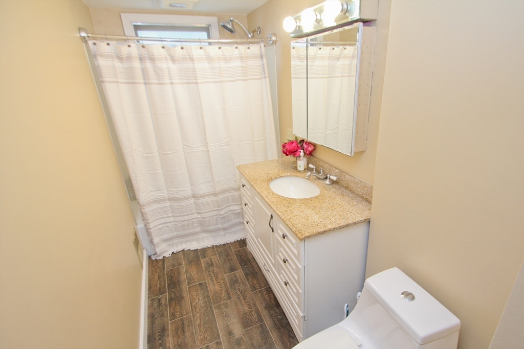 38 Virginia Street Springfield, MA 01108 - Photo 19 of 42 a bathroom with a granite countertop sink a mirror and shower curtain