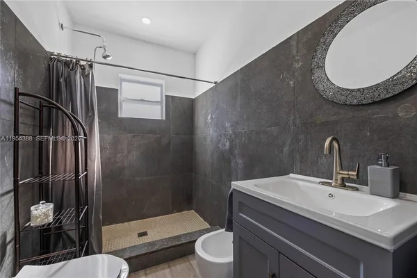 a bathroom with a sink toilet a mirror and shower